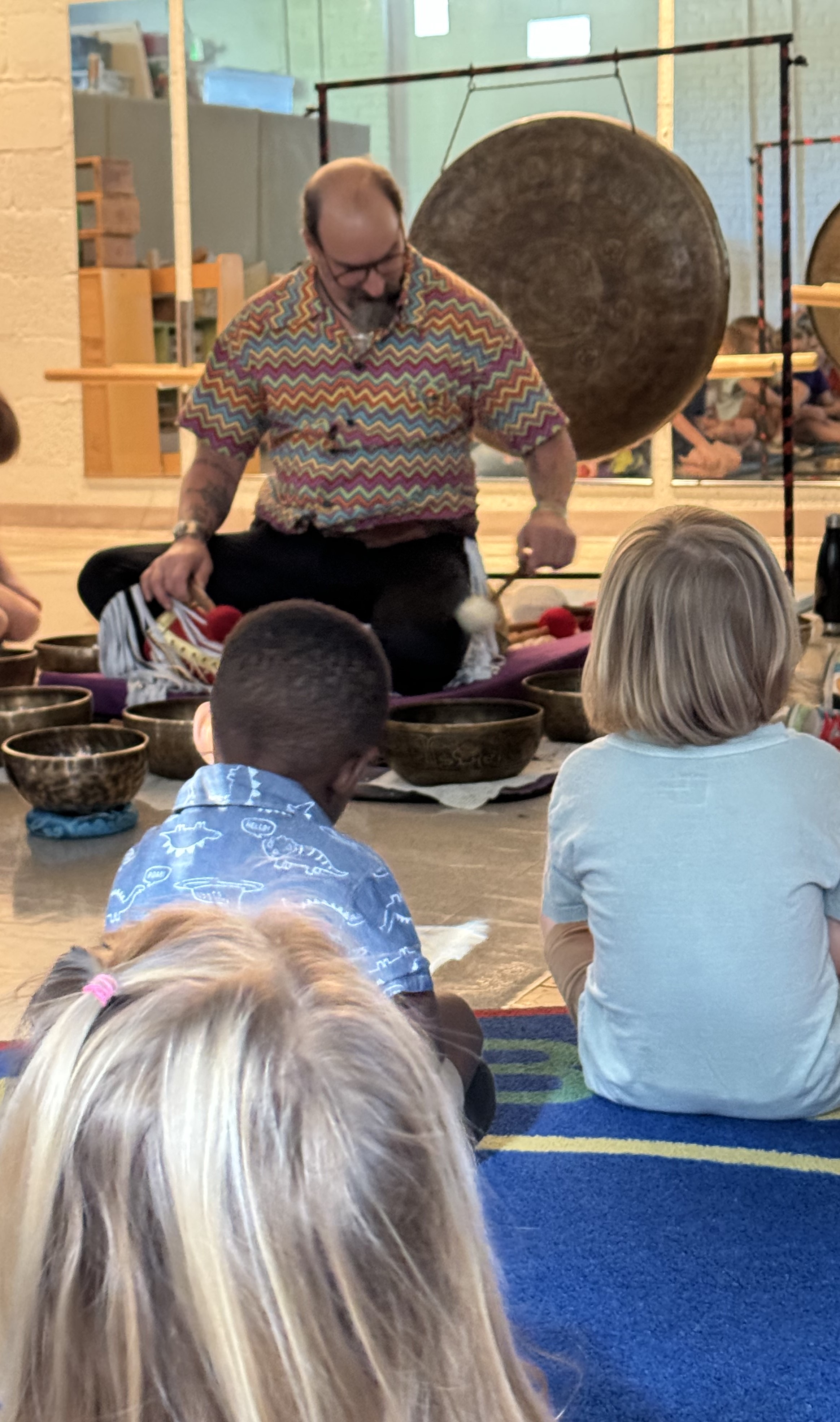 Christian playing the large bowls in front of attentive children