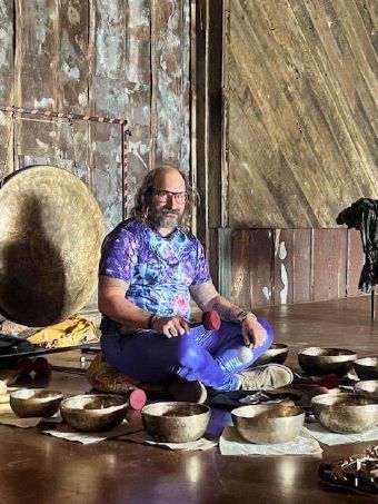 Christian in front of gong surrounded by singing bowls